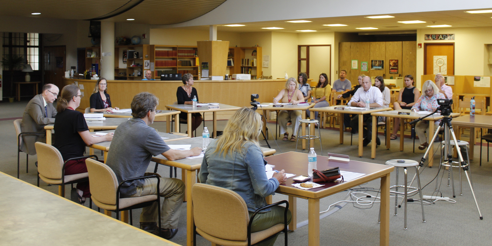 members of the Board of Education, legal counsel and the district superintendent are shown at a table